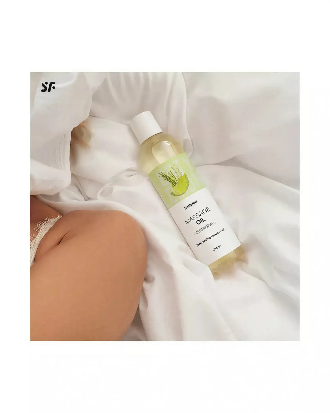 Satisfyer massage oil in lemongrass scent, 250ml bottle on a white fabric background.