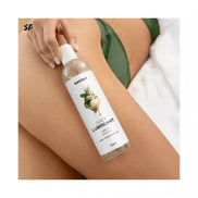 Satisfyer Juicy Lubricant 300ml bottle with minty mocha flavor, held by a hand on a thigh with green fabric.