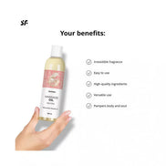 Satisfyer Massage Oil Neutral 250ml in a clear bottle with a pink label, held in a hand against a white background.