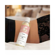 Satisfyer Massage Oil Neutral 250ml bottle on a bed with lace fabric in the background.