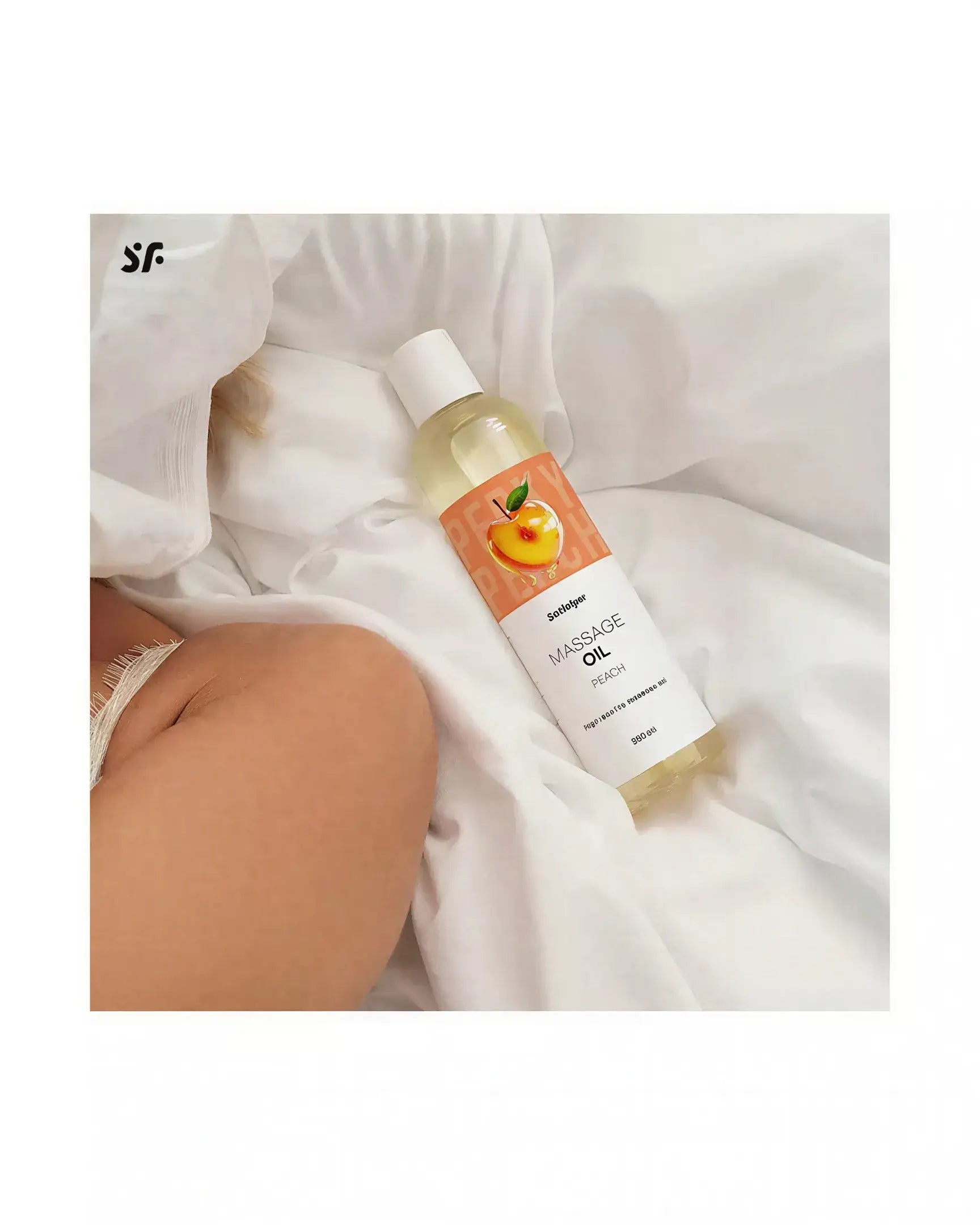 Satisfyer massage oil in a 250ml bottle with a peach label, placed on white fabric.
