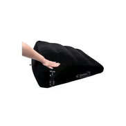 Black inflatable positioner with a hand pressing down on its surface, showcasing its texture and design.