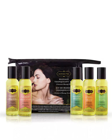 Kama Sutra Massage Tranquility Kit with eight massage oils in clear bottles, displayed with a black pouch and a model in t...