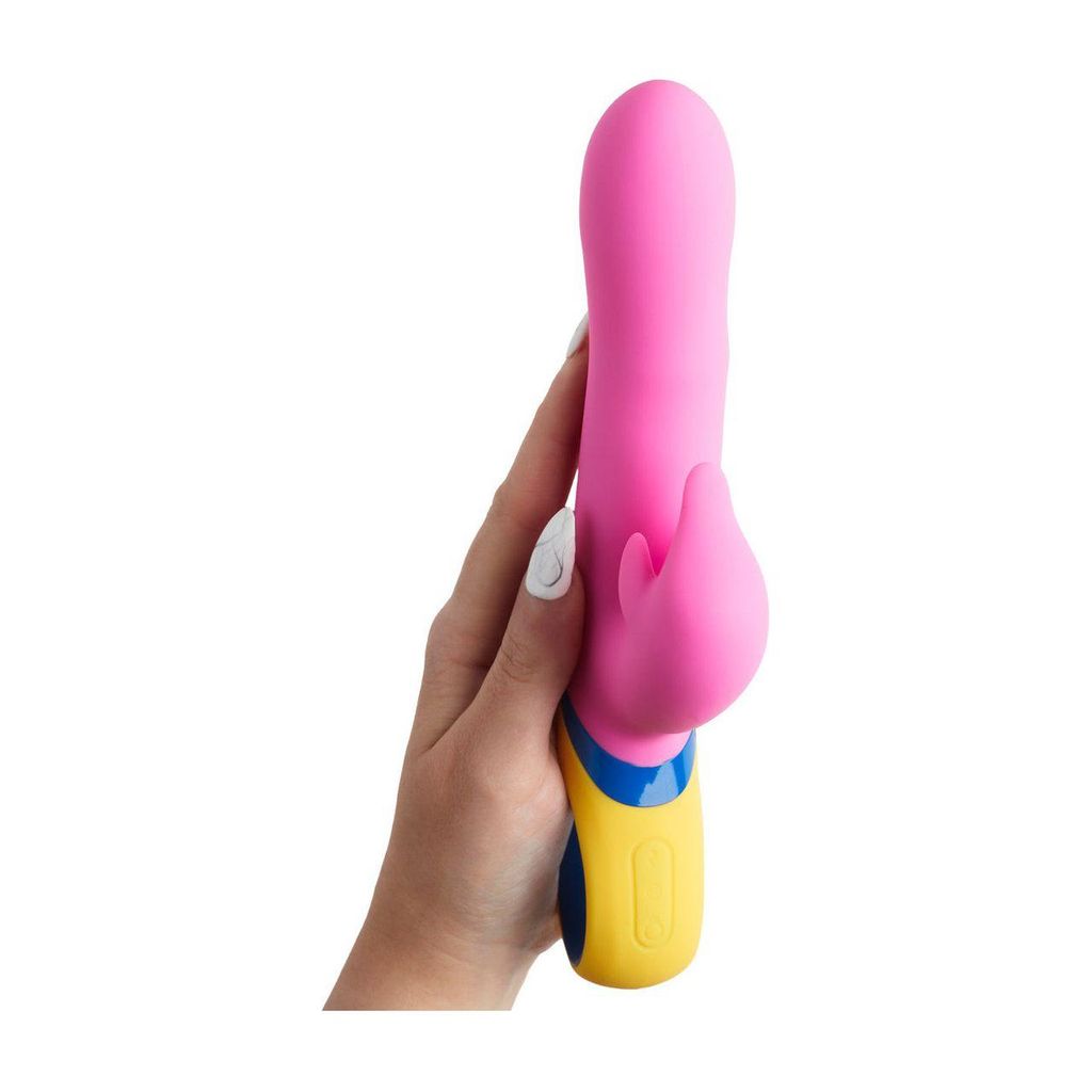 Pink Hanu rabbit vibrator held in a hand, featuring a curved design and a yellow base for easy grip.