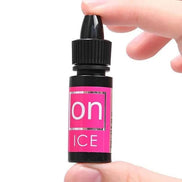 Sensuva On Arousal Oil for Her in a small black and pink bottle held between fingers.